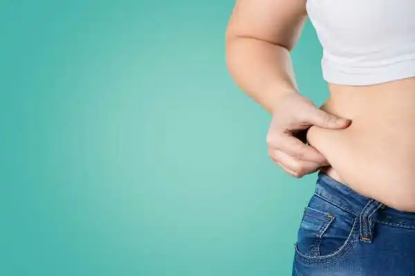Image of woman pinching her love handles to show weight gain St Neots